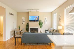 a living room with a couch and a tv on the wall at Spacious 4BR Soulard Duplex with Patio & Parking in Soulard +44 photos