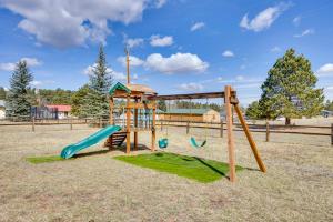 a playground with a slide and a swing at Comforting Woodland Park Home with Fire Pit! in Woodland Park