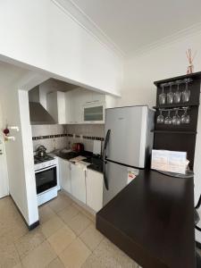 cocina con electrodomésticos blancos y encimera negra en Vero MdP, en Mar del Plata