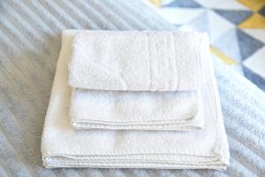 a stack of white towels sitting on a bed at Dekart 2 in Niš +60 photos