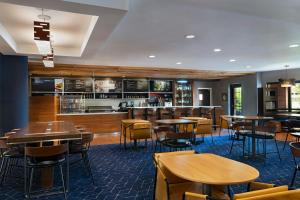 a restaurant with tables and chairs and a bar at Courtyard by Marriott Omaha Aksarben Village in Omaha