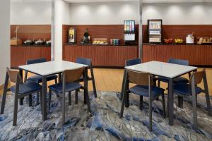 two tables and chairs in a waiting room at Fairfield Inn & Suites by Marriott Charlotte Airport in Charlotte