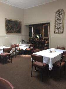 a dining room with tables and chairs and a piano at Royal Hotel Snake Valley in Snake Valley
