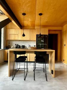 une cuisine avec une grande table en bois et deux tabourets dans l'établissement Casa Gallareta , luxury con costa del lago ., à Villa La Angostura 21 autres photos