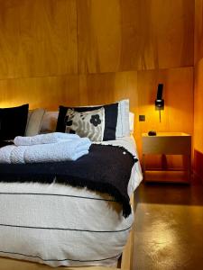- une chambre avec un lit et un mur en bois dans l'établissement Casa Gallareta , luxury con costa del lago ., à Villa La Angostura