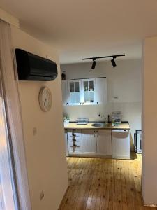 a kitchen with white cabinets and a clock on the wall at Travel Rest in Bujanovac