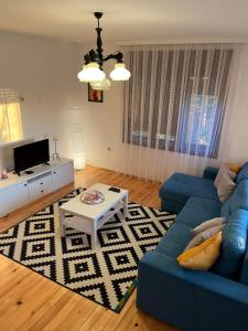 a living room with a blue couch and a table at Travel Rest in Bujanovac