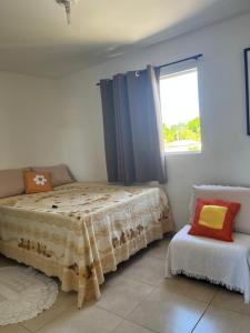 a bedroom with a bed and a window at Flat - Jacumã - Conde in Conde