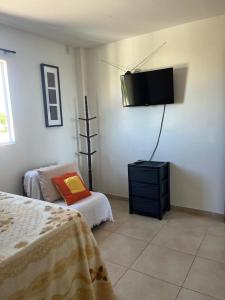 a room with two beds and a flat screen tv at Flat - Jacumã - Conde in Conde +11 photos