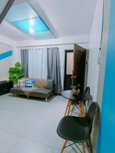 a living room with a table and a couch at Gomez St 2BR Apartment in Downtown- Host Homes in Tacloban +9 photos