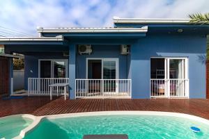 a blue house with a swimming pool in front of it at Pousada Vista Horizonte in Penha