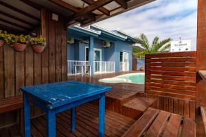 a blue table on the deck of a house with a swimming pool at Pousada Vista Horizonte in Penha