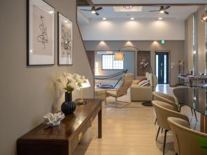 a living room with a table and some chairs at Harmonia 那須,大人数,カラオケ,屋根付きBBQ,敷地内の小川 in Nasu