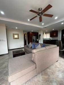 a living room with a couch and a ceiling fan at Monaco Condominiums, Jacó, Costa Rica - Luxury 3 Bedrooms in Jacó