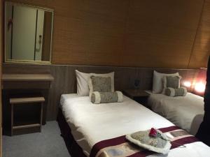 a hotel room with two beds and a mirror at Gu-Ting-Ben B&B in Minxiong