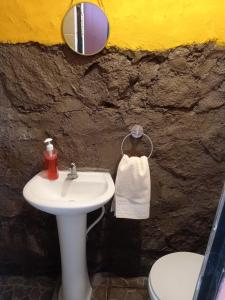 a bathroom with a sink and a mirror and a toilet at Casa de huéspedes libertad in San Salvador