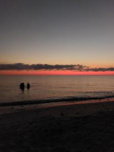 two people in boats in the ocean at sunset at Location saisonnière un salon et deux chambres in Raʼs al Jabal