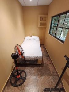 a room with a bed with a fan in it at Casa de huéspedes libertad in San Salvador