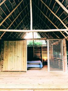ein offener Raum mit einem Bett in einer Hütte in der Unterkunft bungalows tropicaux Jardin exotique in Las Terrenas