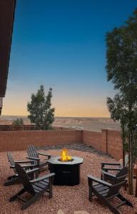a firepit with two chairs and a table with a fire burns at The Retreat - Hot Tub Fire Pit Boat Parking in Page