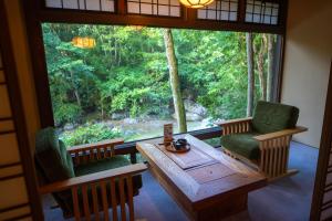 a room with a table and chairs and a large window at Wanosato in Takayama