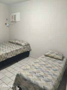 two beds sitting next to each other in a room at Apartamento Bem Localizado in Cuiabá
