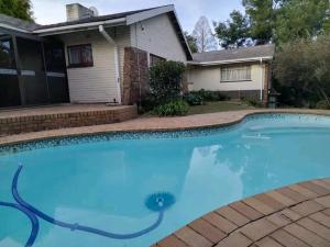a swimming pool in front of a house at Nzima BnB in Estcourt