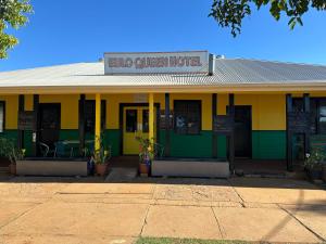The Eulo Queen Hotel的一栋黄色和绿色的建筑，上面有一块牌子，上面写着“两张大床酒店”