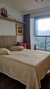 Giường trong phòng chung tại Ap Recreio Junto ao Shopping a 1 km da praia