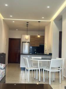 a kitchen with a white table and white chairs at المضيق in Marina Smir