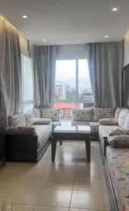 a living room with couches and a large window at المضيق in Marina Smir