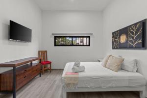a bedroom with a bed and a desk and a television at Casona Santa Rita Bucerias in Bucerías