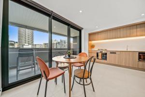 パースにあるPerthViews Modern with Pool Gymのテーブルと椅子のあるキッチンとダイニングルーム