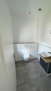 ein weißes Badezimmer mit Toilette und Waschbecken in der Unterkunft Ferienzimmer No4 Ehingen in Ehingen