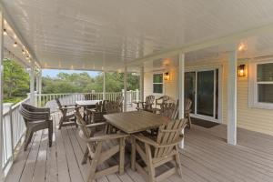 a porch with a wooden table and chairs on it at Ft Morgan Bama Belle-Beach Access in Gulf Shores