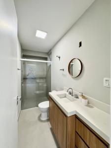 ein Badezimmer mit Waschbecken, Toilette und Spiegel in der Unterkunft Apartamento no Centro - conforto e praticidade in Florianópolis