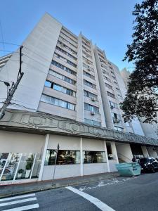 ein großes weißes Gebäude mit Fenstern auf einer Straße in der Unterkunft Apartamento no Centro - conforto e praticidade in Florianópolis