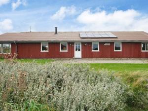 una casa roja con paneles solares. en 10 person holiday home in Harboøre-By Traum, en Harboør