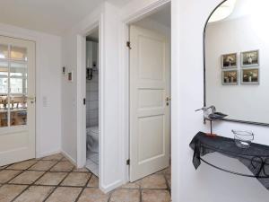 a hallway with a white door and a mirror at 8 person holiday home in Dannemare-By Traum in Dannemare +33 photos