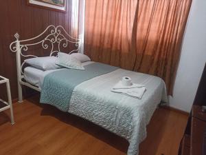 a bedroom with a bed with a tray with a roll on it at Hostal Huapry in Quito