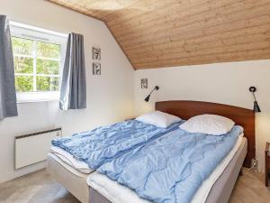 1 dormitorio con cama con edredón azul y ventana en 12 person holiday home in Væggerløse-By Traum, en Bøtø By 33 fotos más