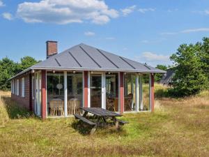 a small house with a picnic table in a field at Tranquil Retreat near Beach - By Traum Ferienwohnungen in Fanø