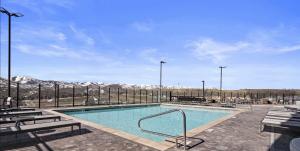 ein Schwimmbad mit Bänken und schneebedeckten Bergen in der Unterkunft Luxury Black Rock Resort Suite Unit B in Heber City