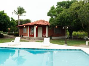 a house with two chairs and a swimming pool at Dulce Vida - Casa con piscina a 200 mts de la Playa Punta Chame in Punta Chame
