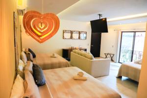 een kamer met twee bedden en een hart aan de muur bij Hotel Diosa del Agua Bacalar in Bacalar