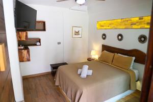 een slaapkamer met een bed met een wit kruis erop bij Hotel Diosa del Agua Bacalar in Bacalar