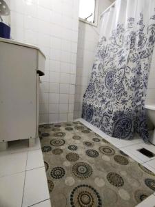 a bathroom with a shower curtain and a tile floor at Central y Comodo Departamento in Buenos Aires +3 photos