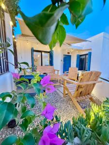 a patio with two chairs and purple flowers at Casa Georgia at Kino Bay - Moderna y acogedora. in Bahía Kino