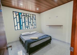 a small bedroom with a bed and a stained glass window at Rancho Buenavista in Vergara +25 photos