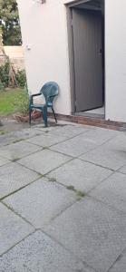 a green chair sitting in front of a building at Clay Stone Cottage in Goodwood +1 photo